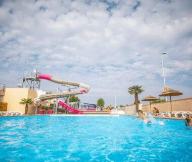 Bassin extérieur avec toboggan et parasols du ZEcamping animaux acceptés club enfant espace aquatique