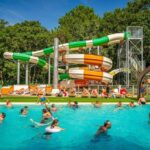 Piscine extérieure avec toboggans et baigneurs au ZEcamping chiens acceptés espace aquatique et bar