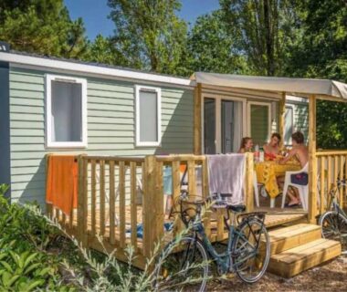 Terrasse de mobil-home avec convives vélos et serviettes au ZEcamping chiens acceptés espace aquatique et bar
