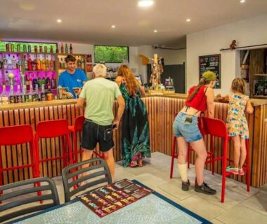 Bar intérieur avec comptoir et clients au ZEcamping chiens acceptés espace aquatique et bar