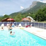 Piscine extérieure avec baigneurs et transats au ZEcamping dog friendly terrain multisports piscine