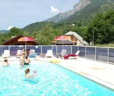 Piscine extérieure avec baigneurs et transats au ZEcamping dog friendly terrain multisports piscine