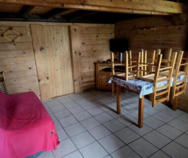 Coin séjour avec canapé et table dans le chalet du ZEcamping dog friendly terrain multisports piscine