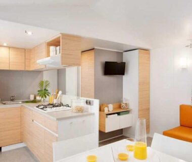 Séjour avec kitchenette, table à manger et canapé dans le mobil home ZEcamping familial espace aquatique pet friendly