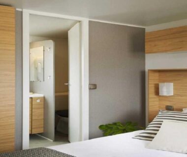 Intérieur chambre avec lit et salle d'eau dans le ZEcamping familial espace aquatique pet friendly