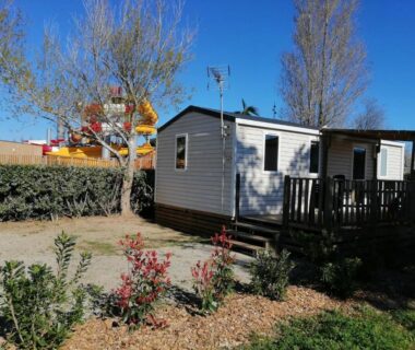 Allée et mobil-home avec terrasse du bungalow au soleil camping les dunes
