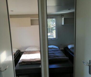 Chambre avec lits et fenêtre dans le bungalow au soleil camping les dunes