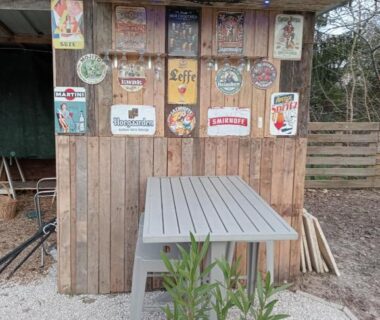 Coin bar en bois décoré d'enseignes vintage au camping cabane perchée et le chêne