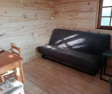 Intérieur de cabane avec canapé et table en bois dans la cabane perchée Le Chêne