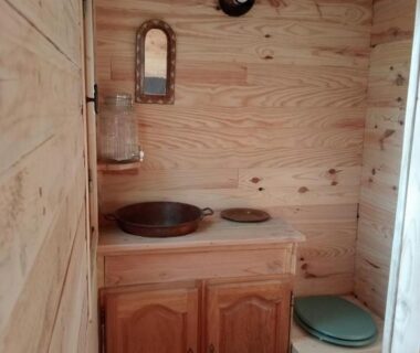 Salle de bain en bois avec lavabo et toilette de la cabane perchée et le chêne