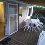 Terrasse du mobil-home avec chaises blanches au camping 4**** proche mer
