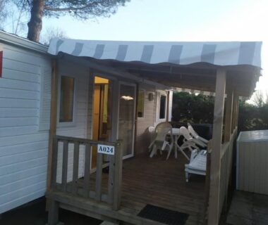 Terrasse couverte avec chaises et store banne du mobil-home A024 au camping 4**** proche mer