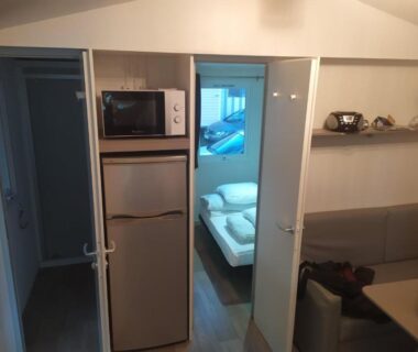 Intérieur du mobil-home avec kitchenette et chambre au camping 4**** proche mer