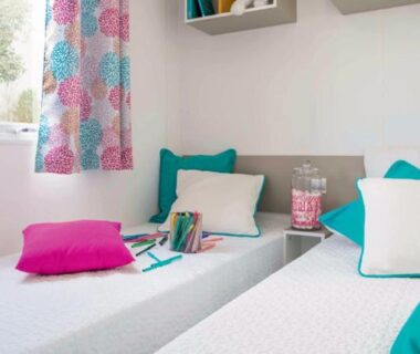 Chambre avec deux lits et étagères dans le camping Le moulin