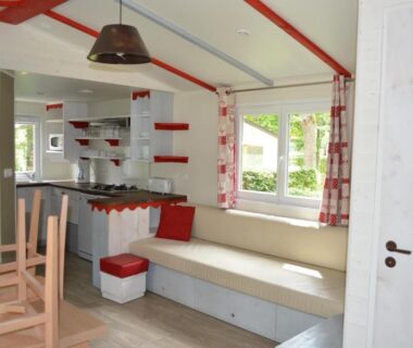Intérieur de mobil-home avec banquette et kitchenette au camping Le moulin