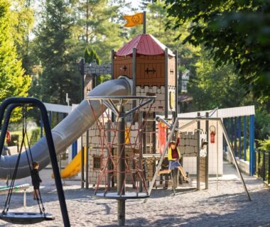 Aire de jeux avec toboggan et balançoires au camping Le moulin