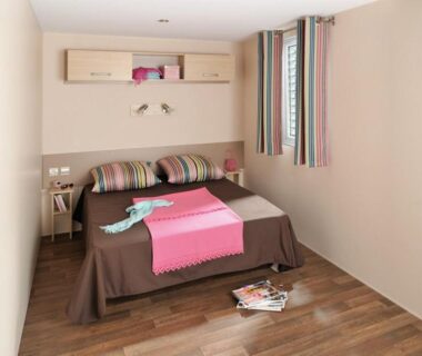 Chambre avec lit double et fenêtre au camping Le moulin