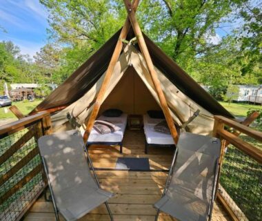 Terrasse en bois avec deux fauteuils et tente glamping au camping Youpendi