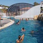Piscine extérieure avec dôme rétractable et rochers au camping de la falaise à Équihen-Plage