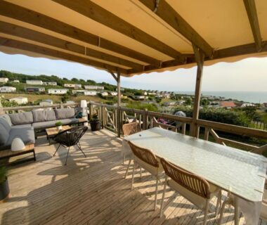 Terrasse couverte avec table et salon extérieur au camping de la falaise à Equihen Plage