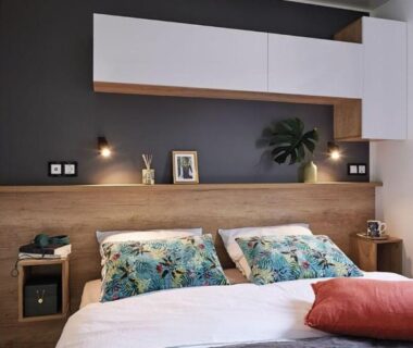 Chambre avec lit double luminaires et rangement au camping haipenée