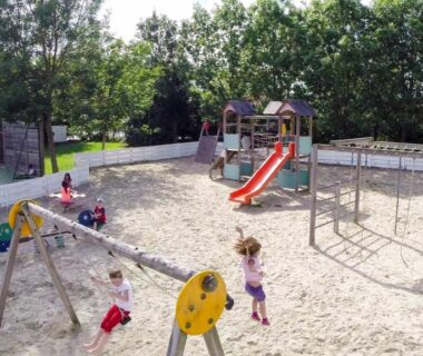 Aire de jeux sur sable avec toboggan et balançoires au camping haipenée