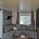 Salon intérieur avec canapé d'angle dans le camping la carabasse