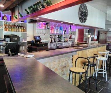 Bar intérieur avec comptoir et tabourets au camping le Fief d'Anduze