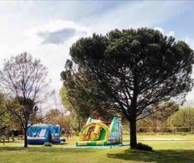 Espace vert avec structure gonflable et caravane au camping le Fief d'Anduze