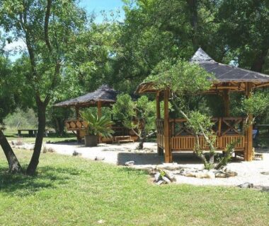 Kiosques en bois ombragés sous chênes dans le camping le Fief d'Anduze