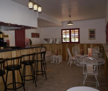 Bar intérieur avec comptoir et tables au camping le Fief d'Anduze