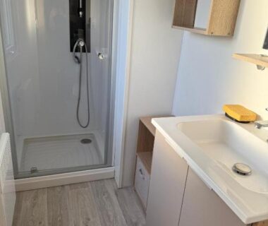 Salle de bain avec douche et lavabo dans le camping le residentiel de la mer