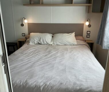 Chambre avec lit double et appliques dans le camping le residentiel de la mer