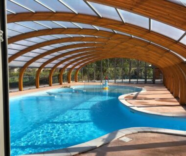 Piscine couverte sous voûtes en bois au camping les pêcheurs