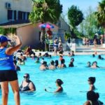Piscine extérieure avec baigneurs au camping les sables du midi