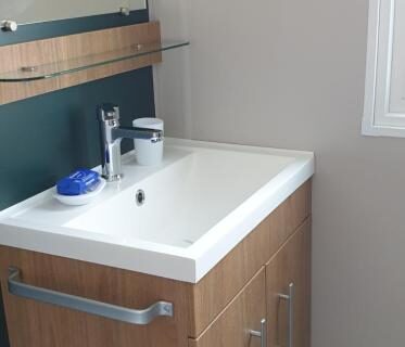 Salle de bain avec lavabo et meuble dans le camping les sables du midi