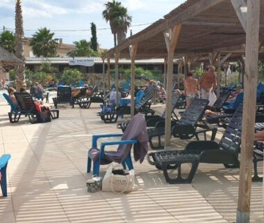 Bord de piscine avec transats parasols et chaises au camping les sables du midi