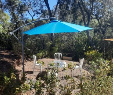 Terrasse ombragée avec parasol et chaises au mobil home climatisé 3 chambres du domaine du Pin de la Lègue