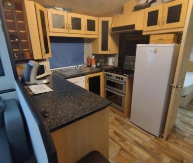 Coin cuisine équipé avec réfrigérateur cuisinière et rangements dans le mobil-home du camping proche du Touquet