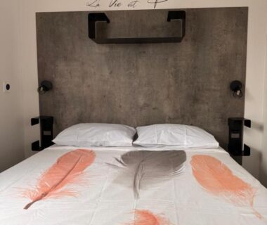 Chambre avec lit double et tête de lit au camping sol a gogo 3 chambres