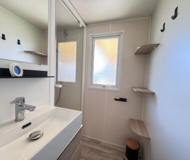 Salle de bain avec lavabo miroir et étagères de la casa Laetitia