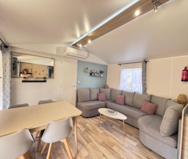 Salon avec coin repas et canapé dans le mobil-home casa Laetitia