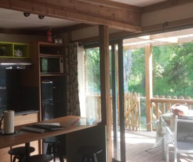 Intérieur ouvert avec coin cuisine et terrasse couverte dans le chalet