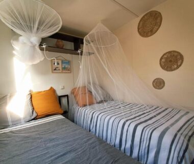 Chambre avec deux lits et moustiquaires dans le cosy mobil home forêt et plage