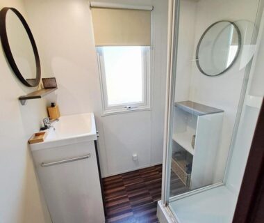 Salle de bain avec douche et lavabo dans le cosy mobil home forêt et plage