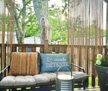 Terrasse ombragée avec banquette et coussins du cosy mobil home forêt et plage