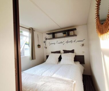 Intérieur chambre avec lit double dans le cosy mobil home forêt et plage