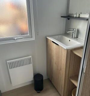 Salle de bains avec lavabo et meuble près de la fenêtre au domaine de litteau