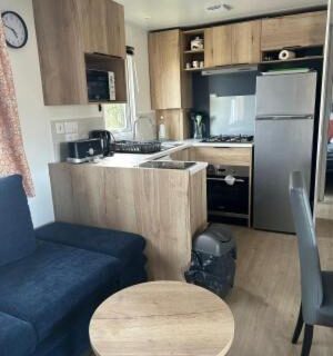 Intérieur mobil-home coin salon et kitchenette dans le domaine de litteau