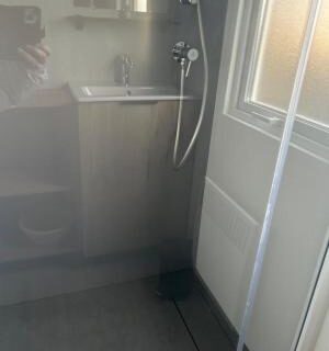 Salle de bains avec douche et lavabo dans le domaine de litteau